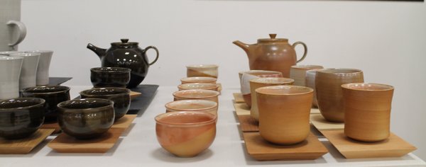 Keramiktöpfe und -schalen auf einem Tisch in einer Galerie