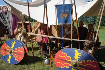 Teilnehmer eines historischen Lagers mit Schilden und Deko
