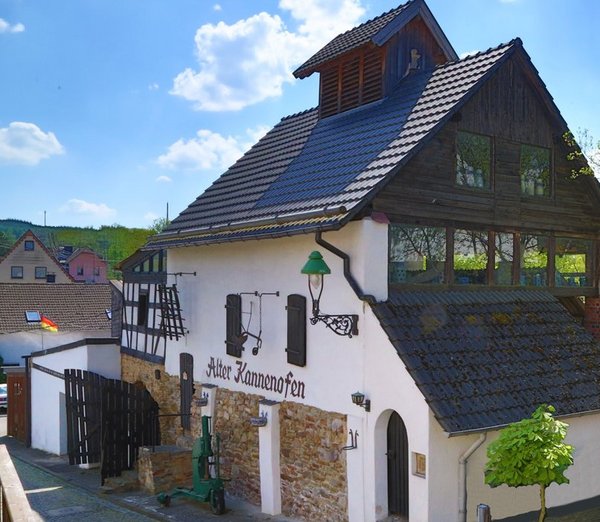 Ein traditionelles Haus mit grünem Baum und blauem Himmel