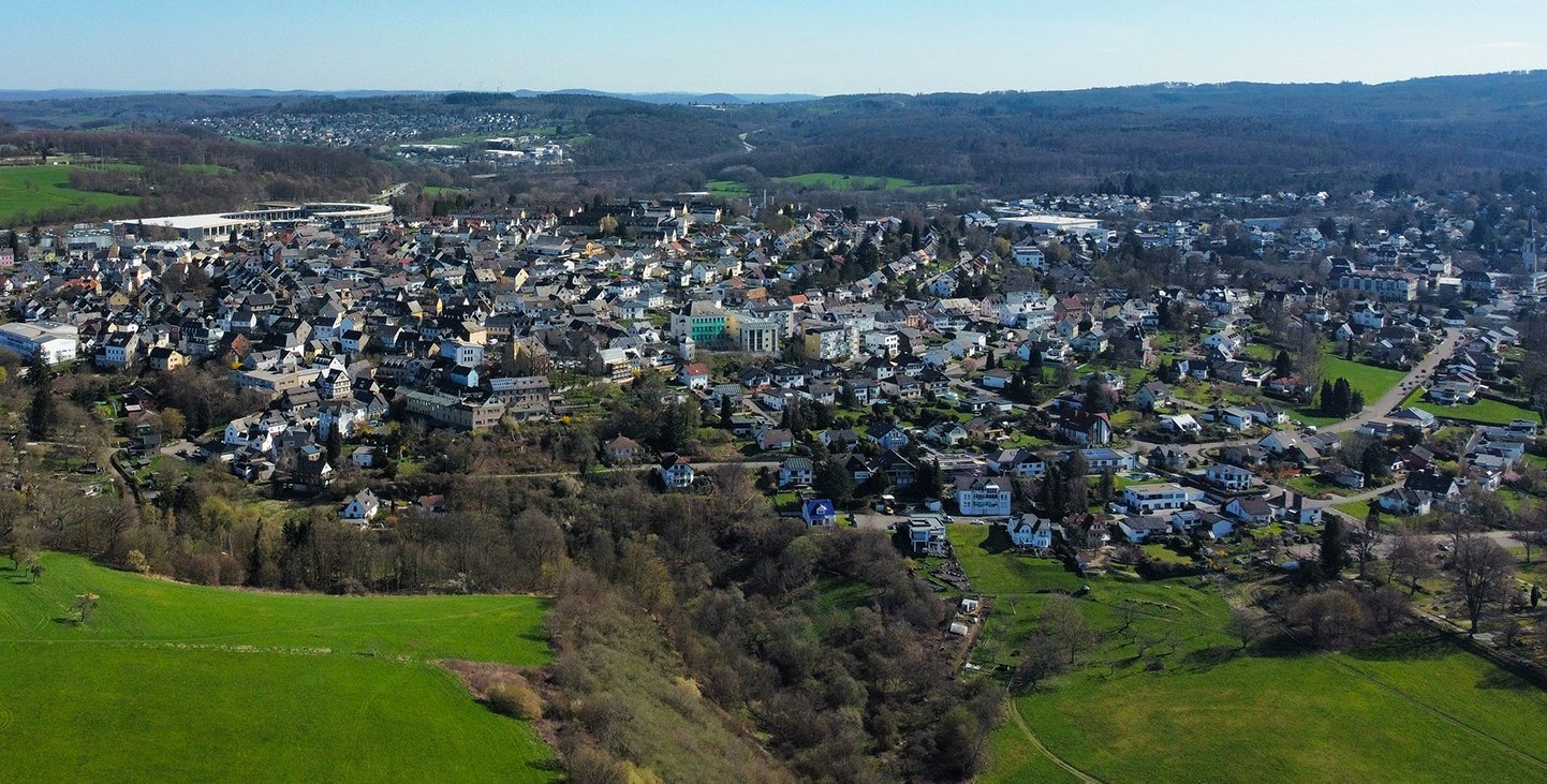 Panoramaansicht einer Stadt umgeben von Grün und Hügeln