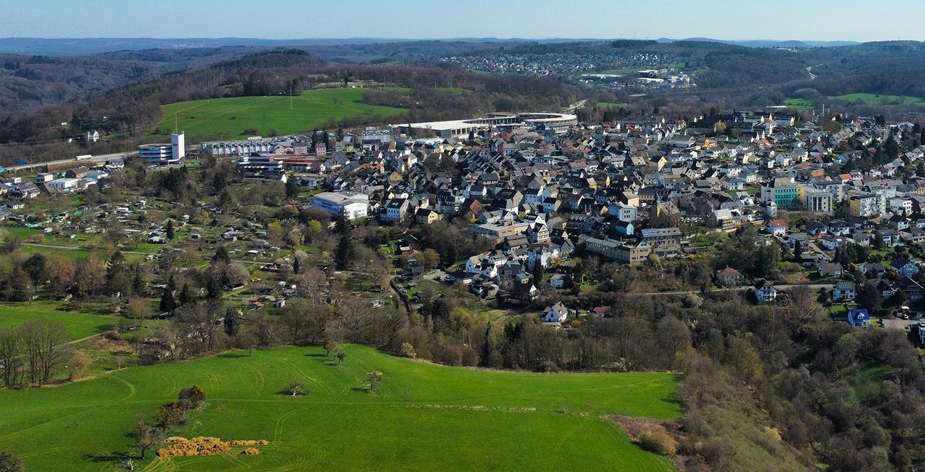 Panoramaansicht einer Stadt umgeben von Grün und Hügeln