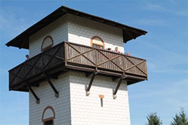Menschen beobachten von einem Aussichtsturm unter blauem Himmel