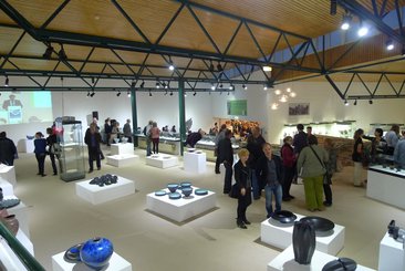 Verschiedene Keramiken und Besucher im Ausstellungsraum