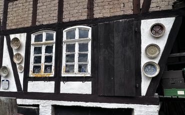 Traditionelles Gebäude mit Fenstern und dekorativen Tellern an der Wand