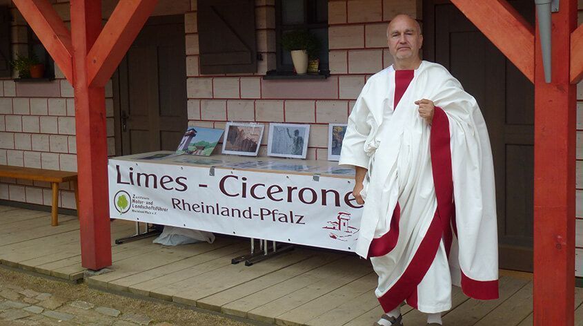 Person in traditioneller römischer Kleidung an einem Informationsstand